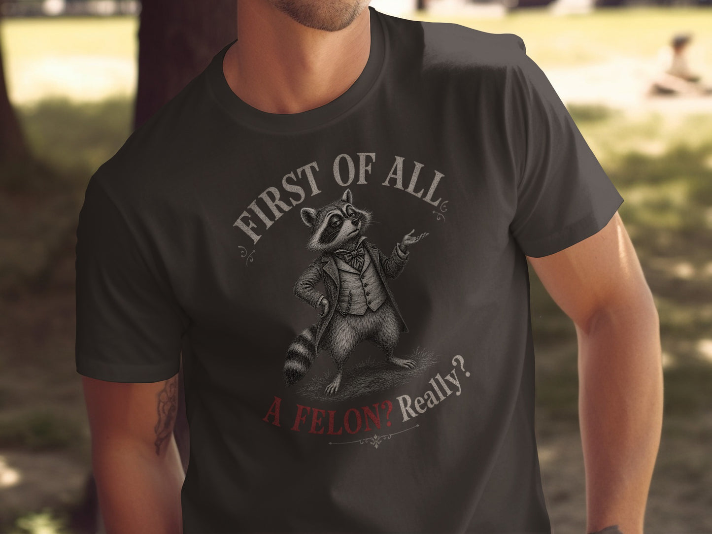 T-shirt with raccoon in a suit saying "First of all, a felon? Really?"