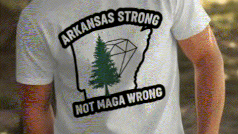 A white t-shirt with a graphic design on the back, featuring a green pine tree and the text "ARKANSAS STRONG NOT MAGA WRONG".