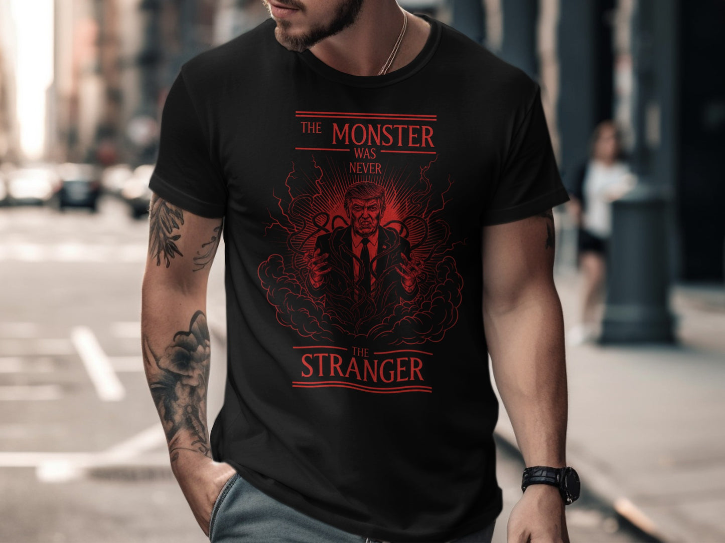 Black t-shirt featuring red graphic of a man and text "The Monster Was Never The Stranger".