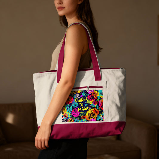 Woman holding a white canvas tote bag with colorful floral "Chinga Tu Madre" graphic.
