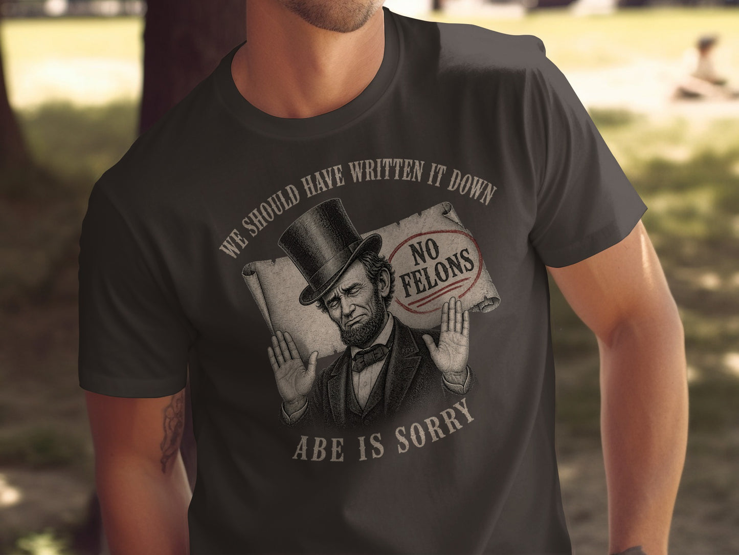 Dark t-shirt with "WE SHOULD HAVE WRITTEN IT DOWN, ABE IS SORRY" and "NO FELONS" stamp.