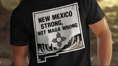 a person wearing a black t-shirt with a graphic design on the back, featuring a message about New Mexico.