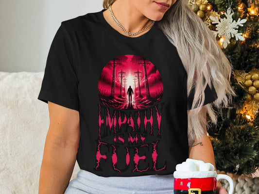 Black t-shirt with "Empathy Is My Fuel" text and silhouette of a person against red sky.