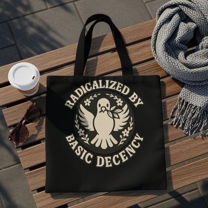 Black tote bag with "Radicalized by Basic Decency" text and a dove emblem.