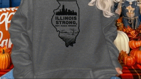 A person wearing a gray sweatshirt with a graphic of the state of Illinois and the text "Illinois Strong" printed on it.