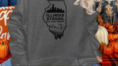 A person wearing a gray sweatshirt with a graphic of the state of Illinois and the text "Illinois Strong" printed on it.