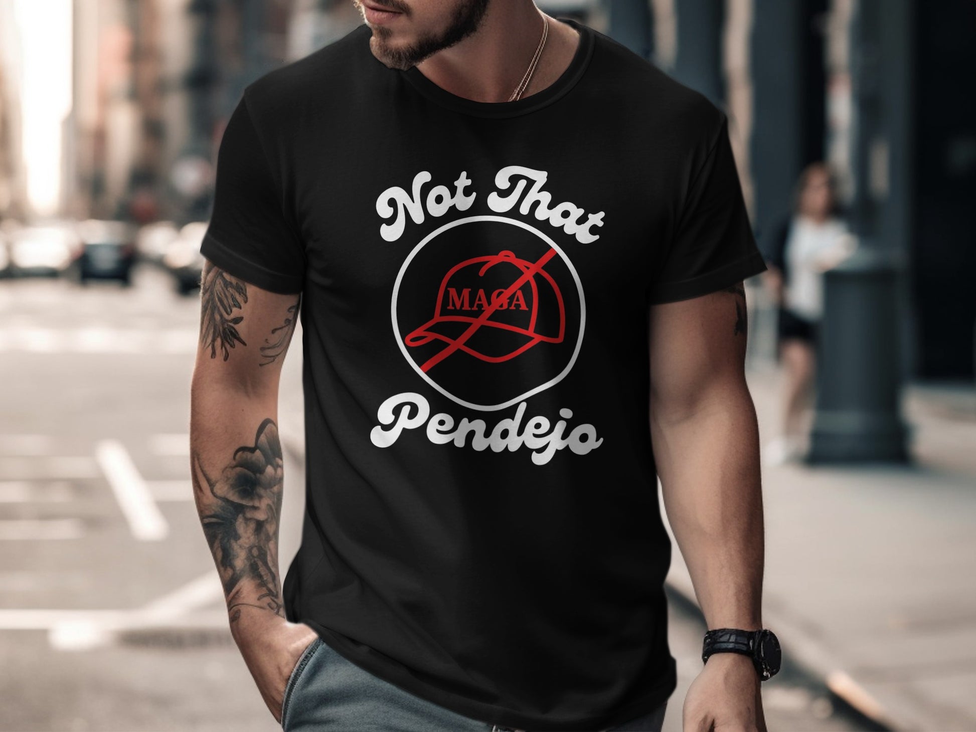 Black t-shirt with "Not That Pendejo" text and a red baseball cap graphic.