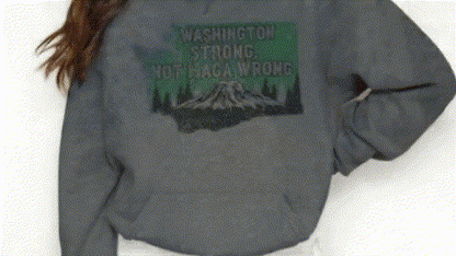 A person wearing a gray sweatshirt with a graphic design on the back.