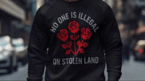 A person wearing a black sweatshirt with a red rose design and text on the back.