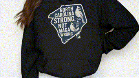 A person wearing a black hoodie with a graphic design on it.