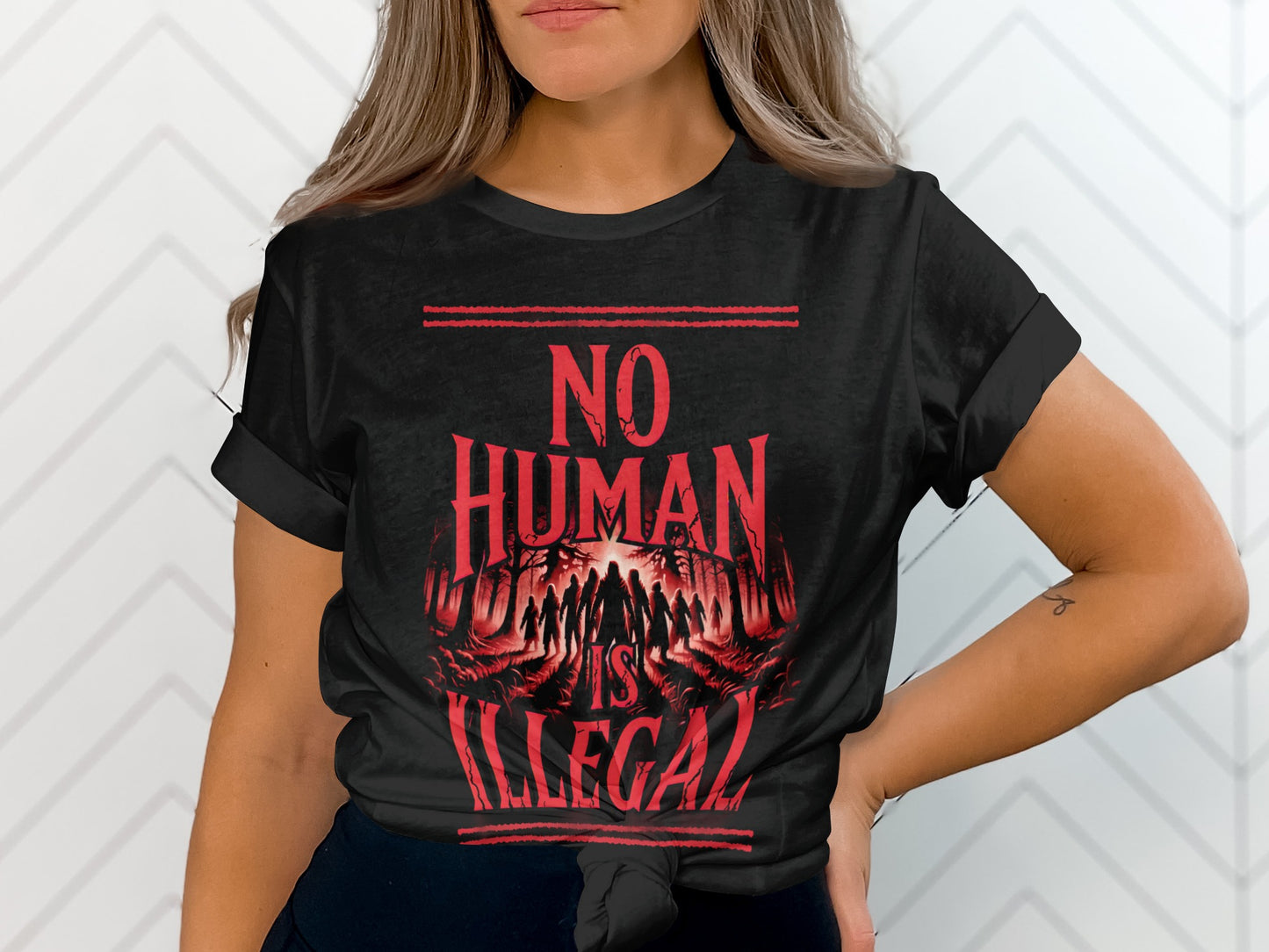 Black t-shirt with "NO HUMAN IS ILLEGAL" text and a crowd of people.