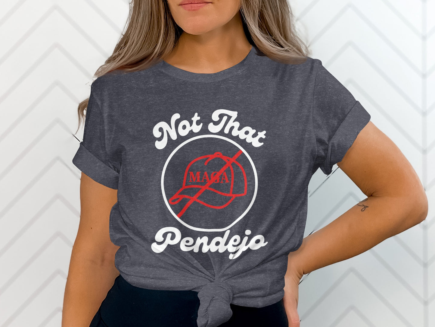 Dark grey t-shirt with "Not That MAGA Pendejo" slogan and crossed-out red hat graphic.