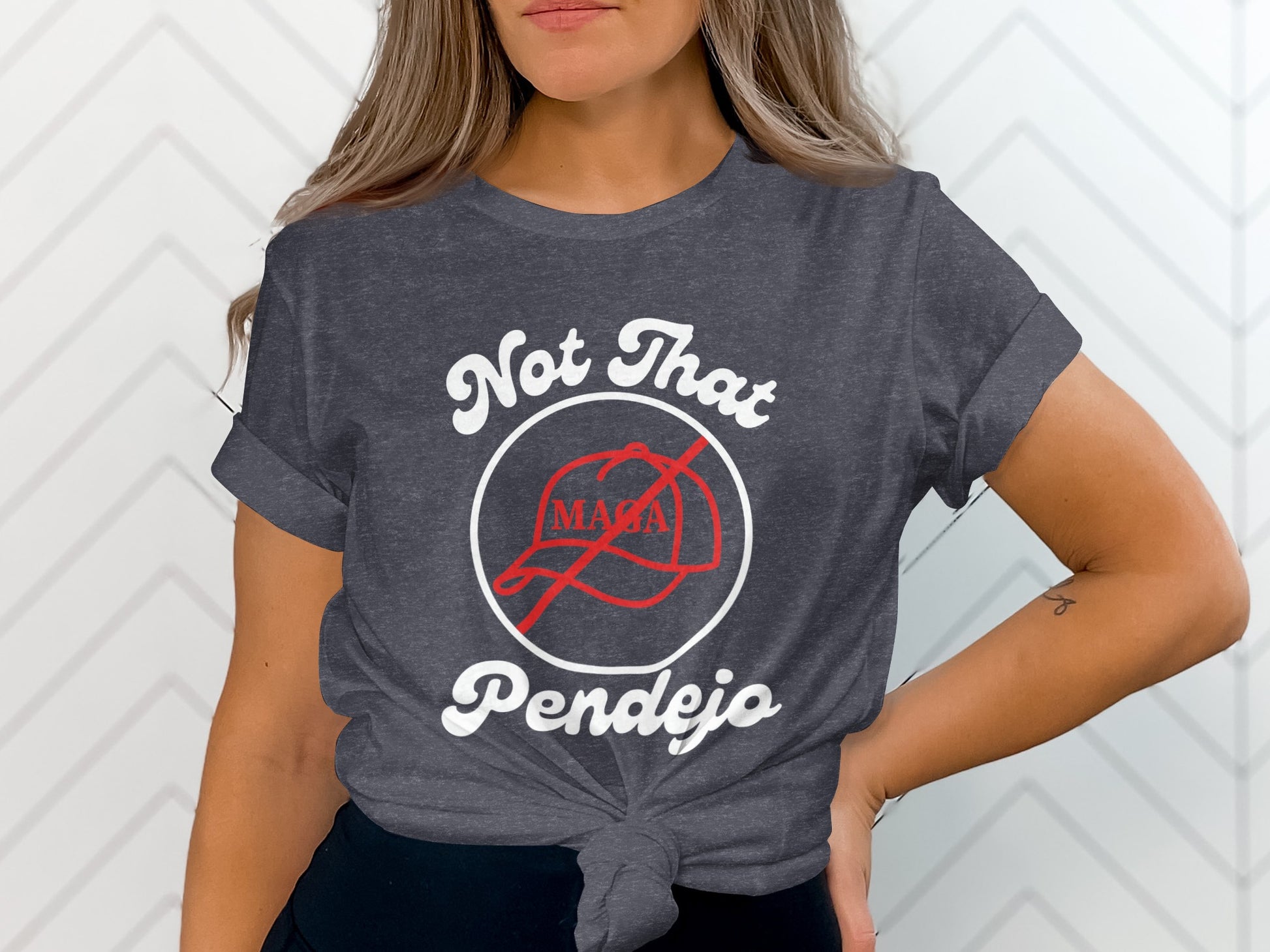 Dark grey t-shirt with "Not That MAGA Pendejo" slogan and crossed-out red hat graphic.
