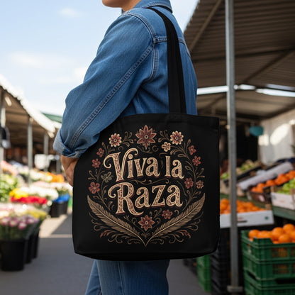 Black tote bag with "Viva la Raza" text and floral border design.