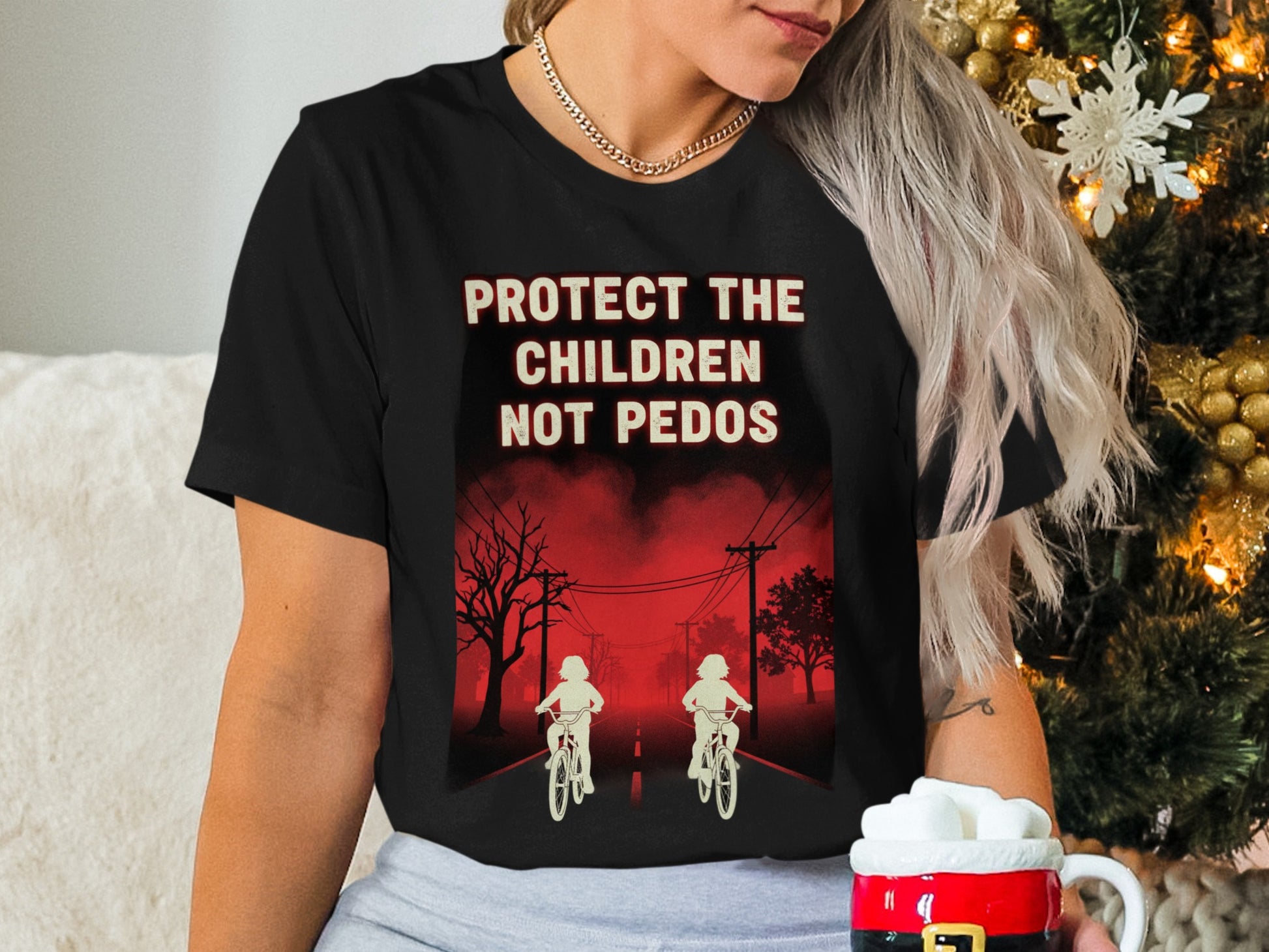 Black t-shirt with red text: "PROTECT THE CHILDREN NOT PEDOS" and two figures on bikes.