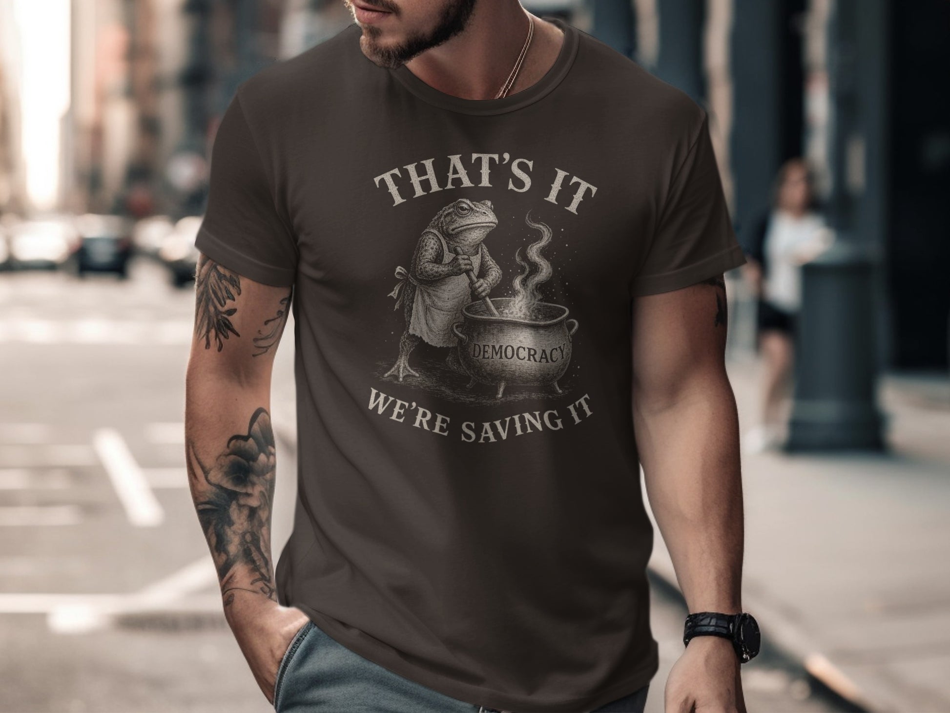 Dark brown t-shirt with a frog stirring a cauldron, text "That's it, we're saving it".