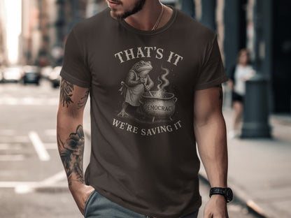 Dark brown t-shirt with a frog stirring a cauldron, text "That's it, we're saving it".