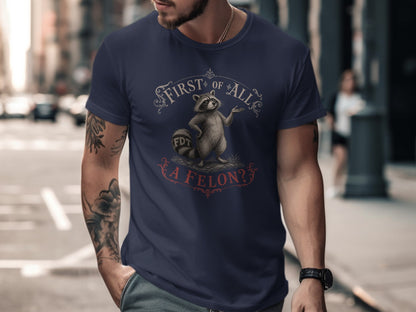 Navy t-shirt with raccoon graphic and "First of All, A Felon?" text.