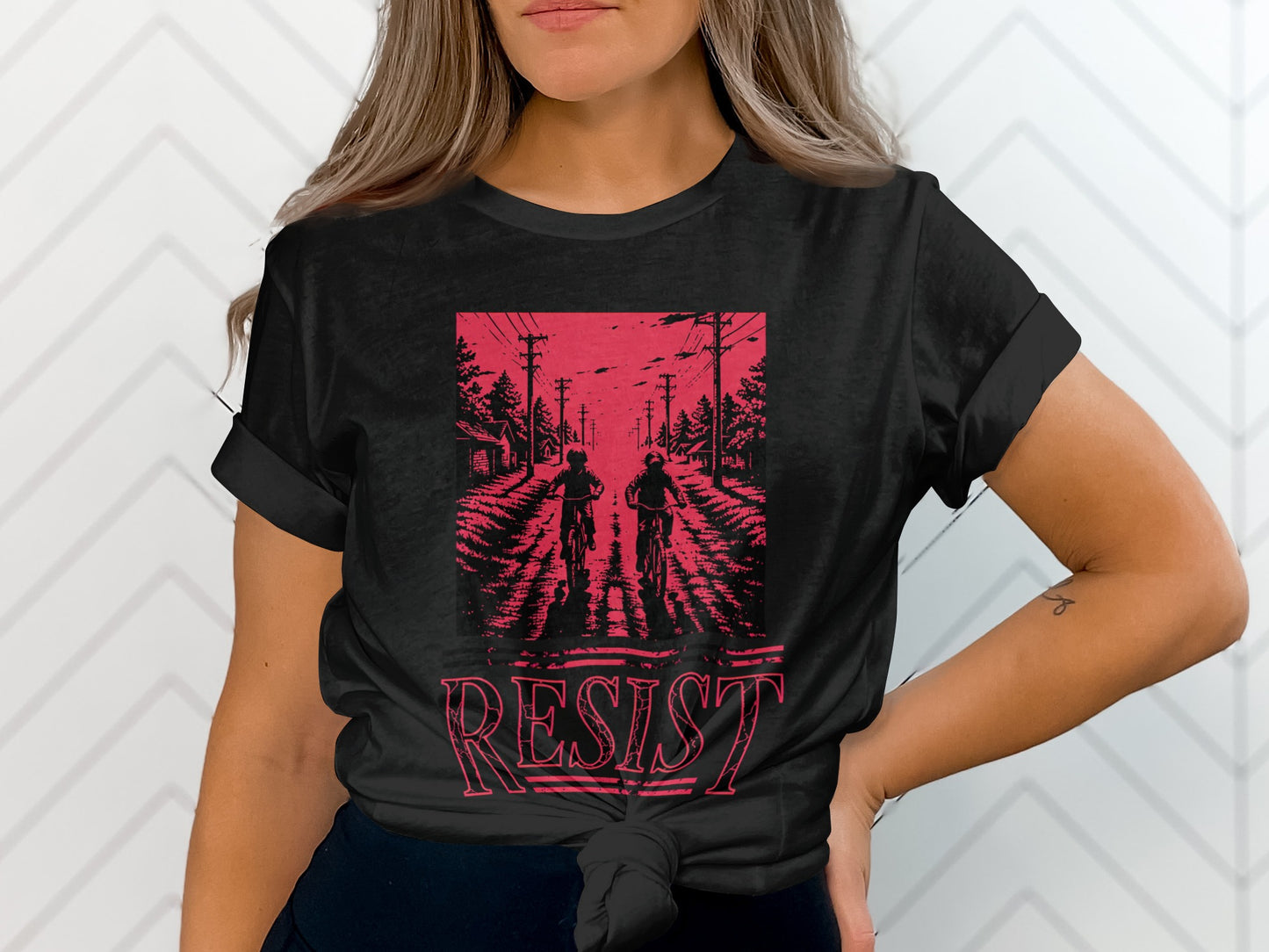 Black t-shirt with two figures on bicycles and "RESIST" text.