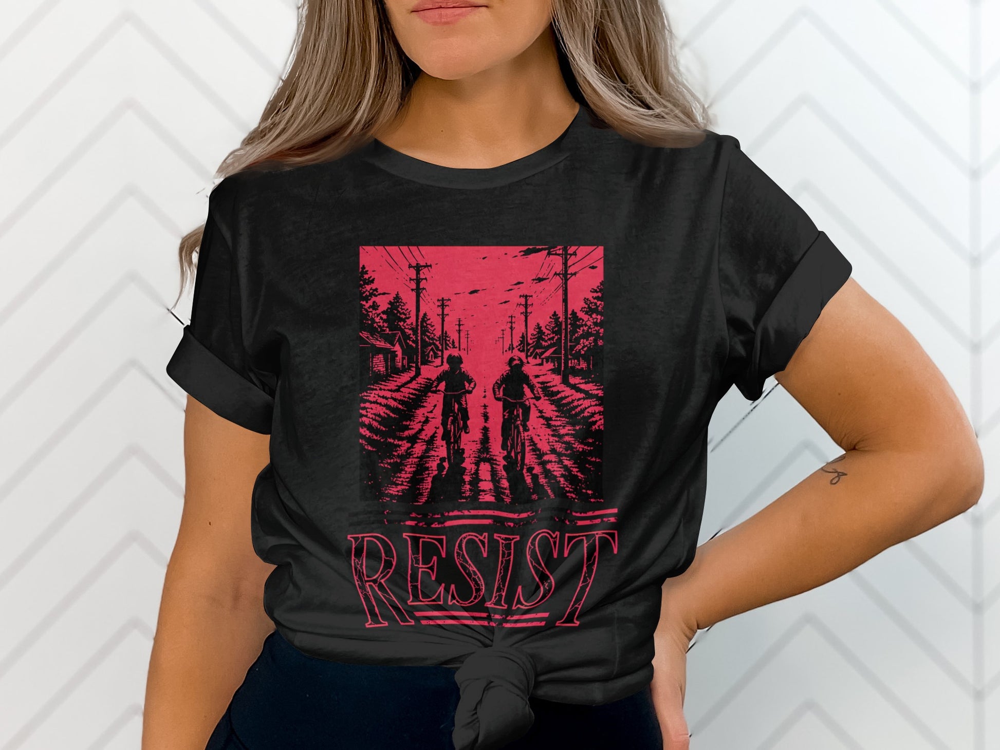 Black t-shirt with two figures on bicycles and "RESIST" text.