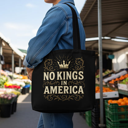 Black tote bag with "No Kings in America" text and crown graphic.