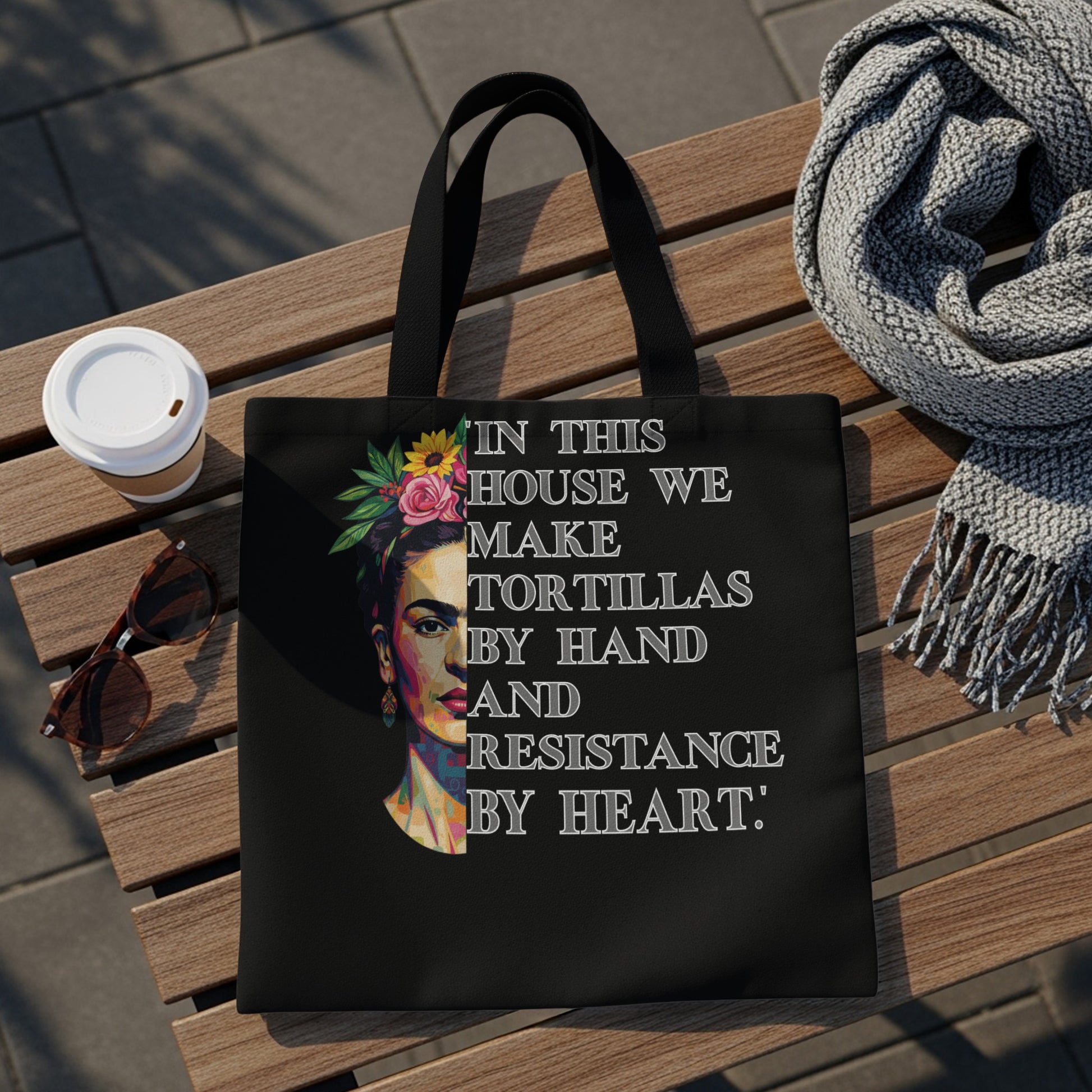 Black tote bag with Frida Kahlo artwork and quote about tortillas and resistance.