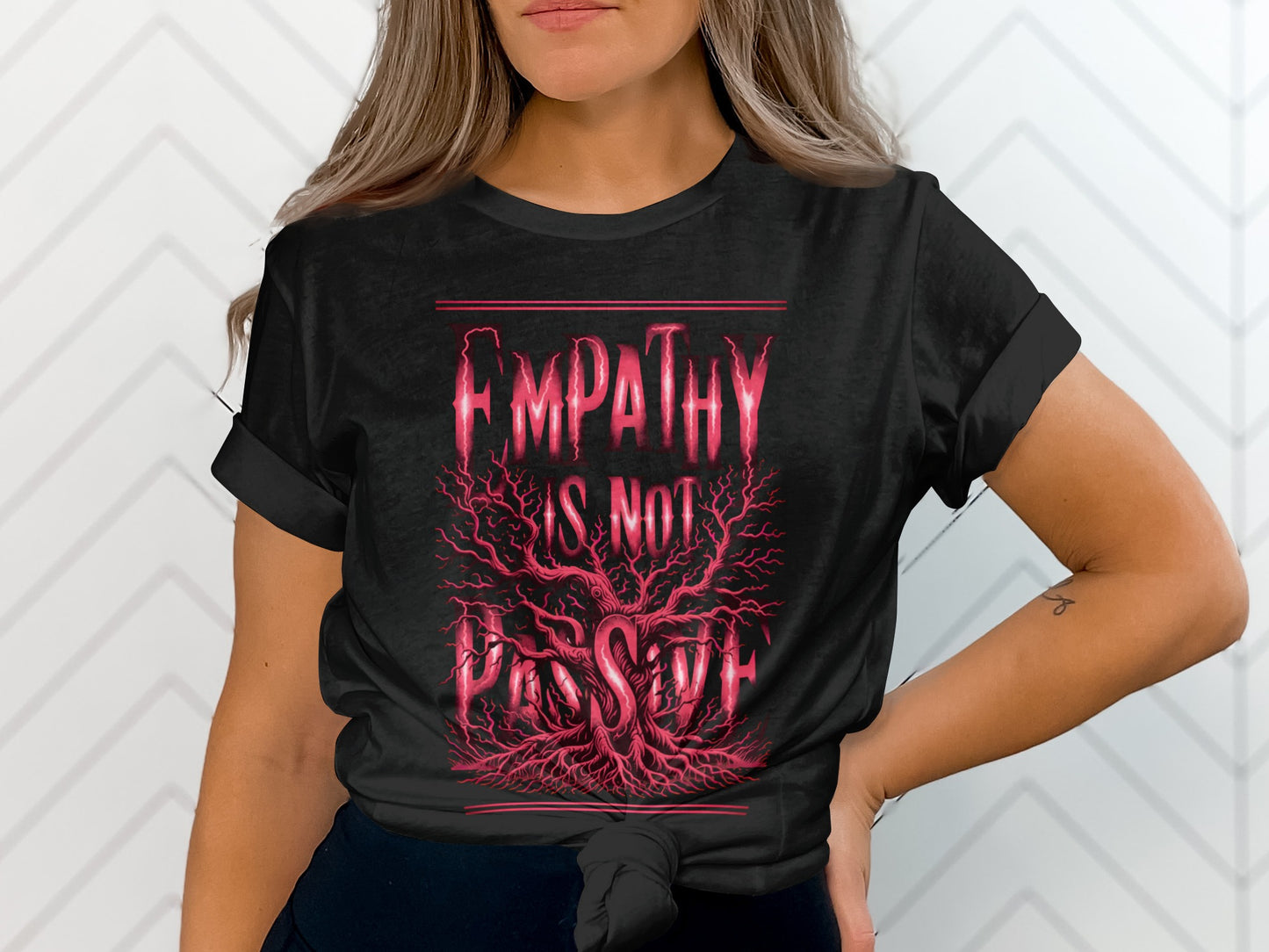Black t-shirt with "EMPATHY IS NOT PASSIVE" in red lettering over a tree with red roots.