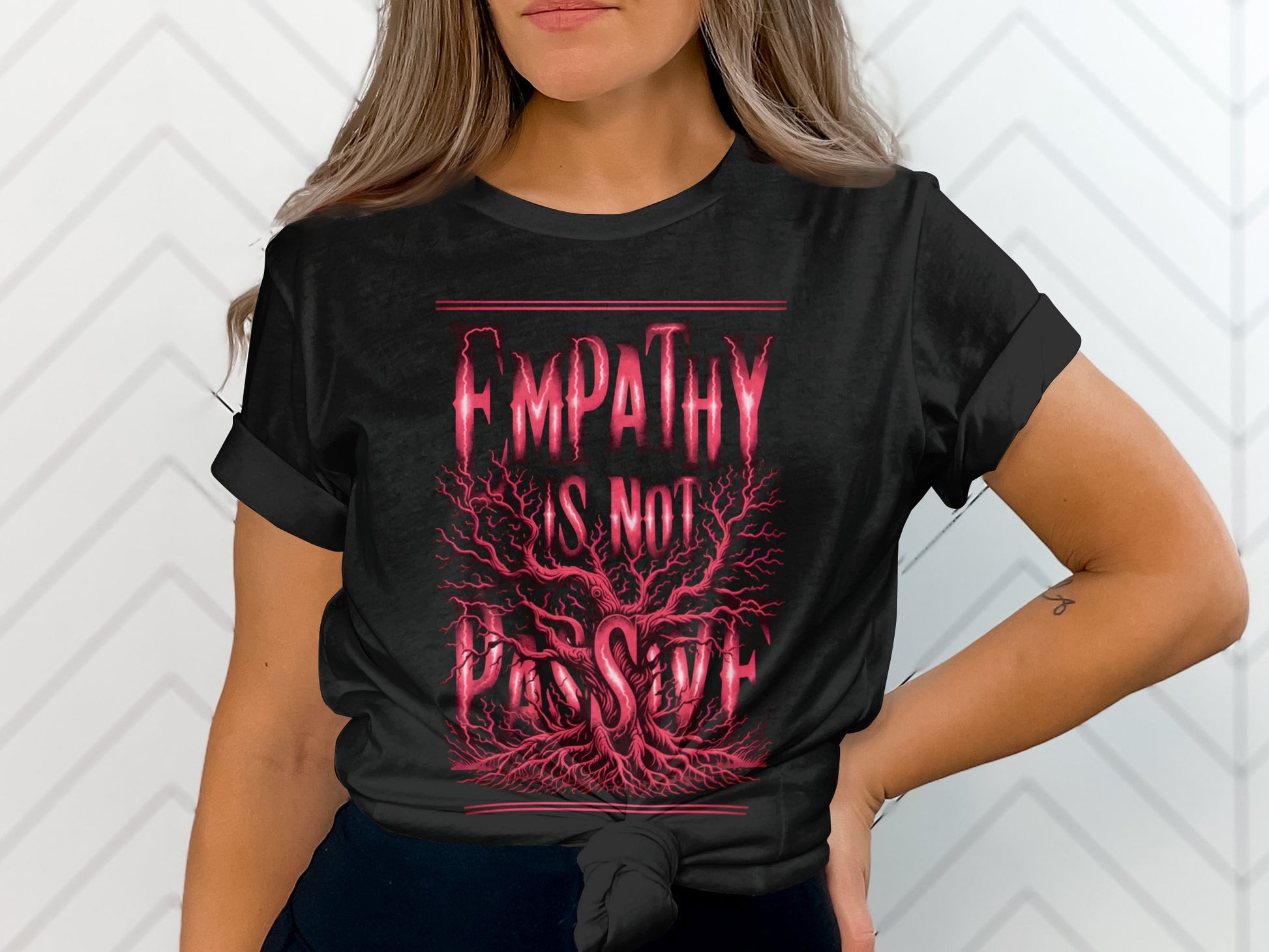 Black t-shirt with "EMPATHY IS NOT PASSIVE" in red lettering over a tree with red roots.