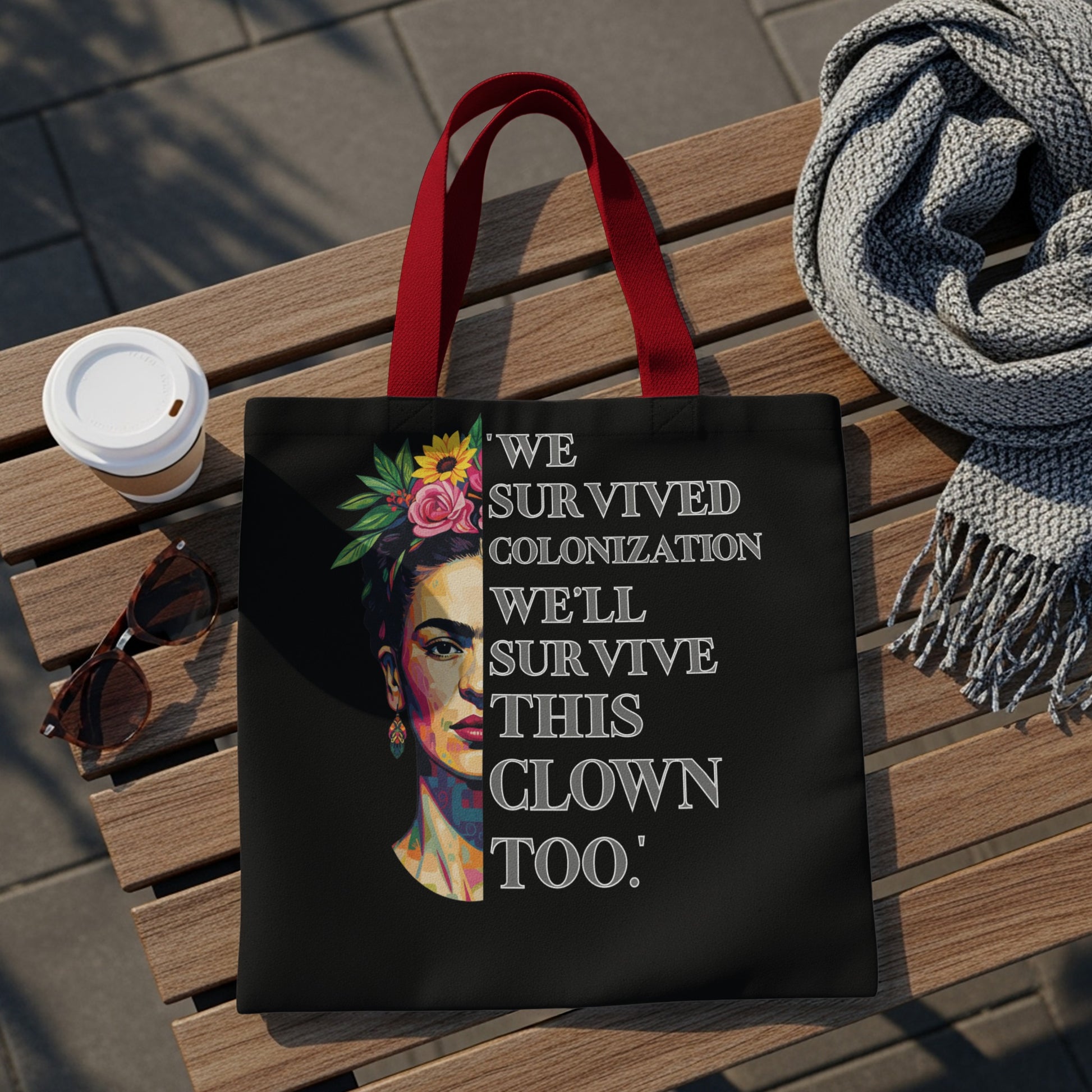 Black tote bag with Frida Kahlo portrait and "We survived colonization, we'll survive this clown too."