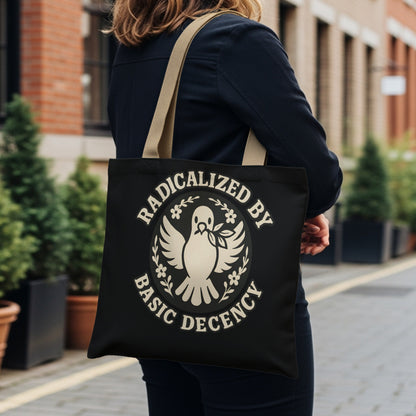 Black tote bag with "Radicalized by Basic Decency" and dove logo.