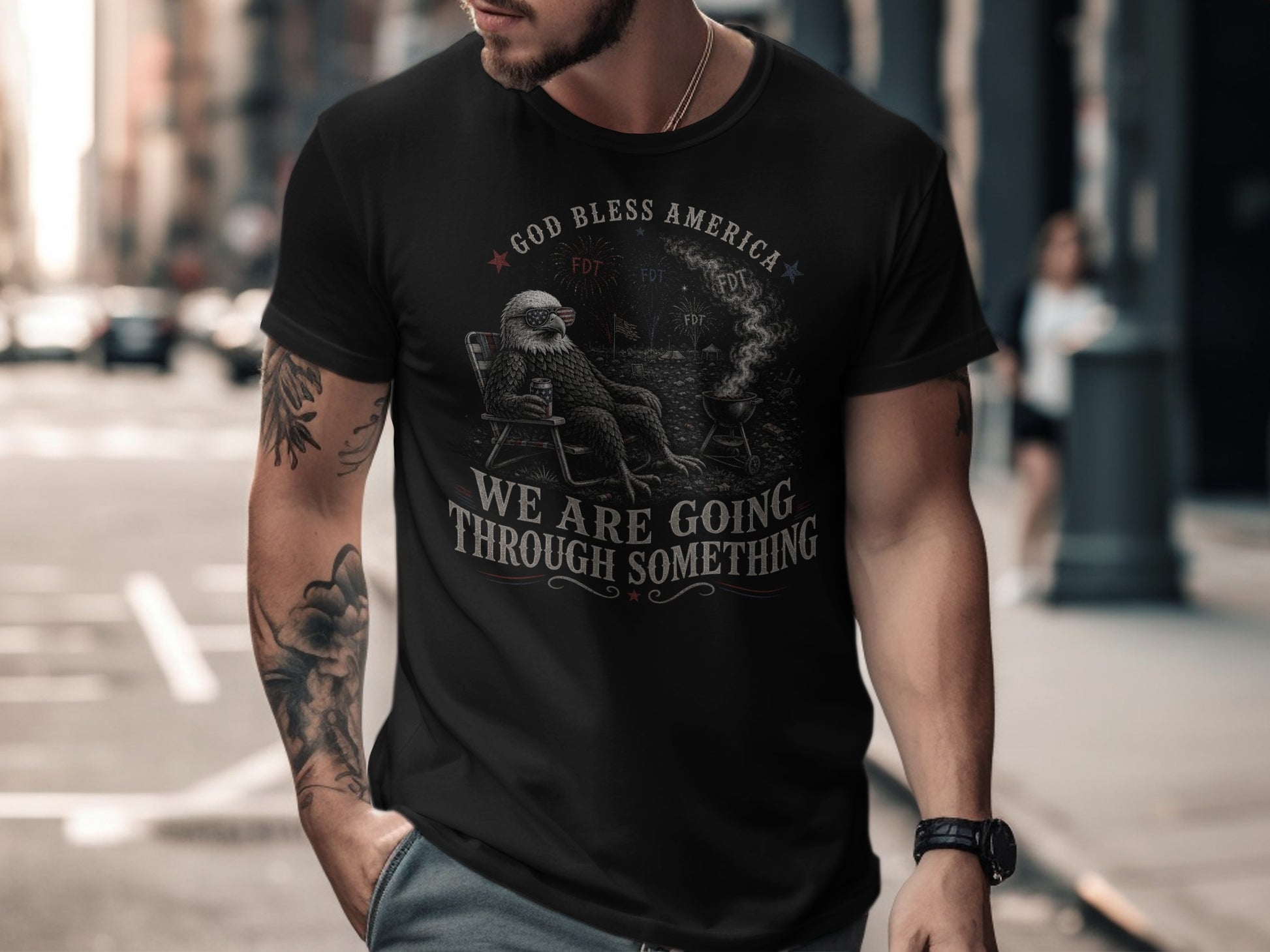 Black t-shirt with "GOD BLESS AMERICA WE ARE GOING THROUGH SOMETHING" graphic.
