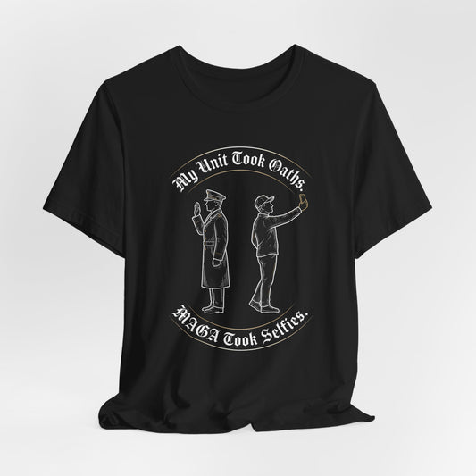 T-shirt with white text "My Unit Took Oaths. MAGA Took Selfies." and line drawing of two men.
