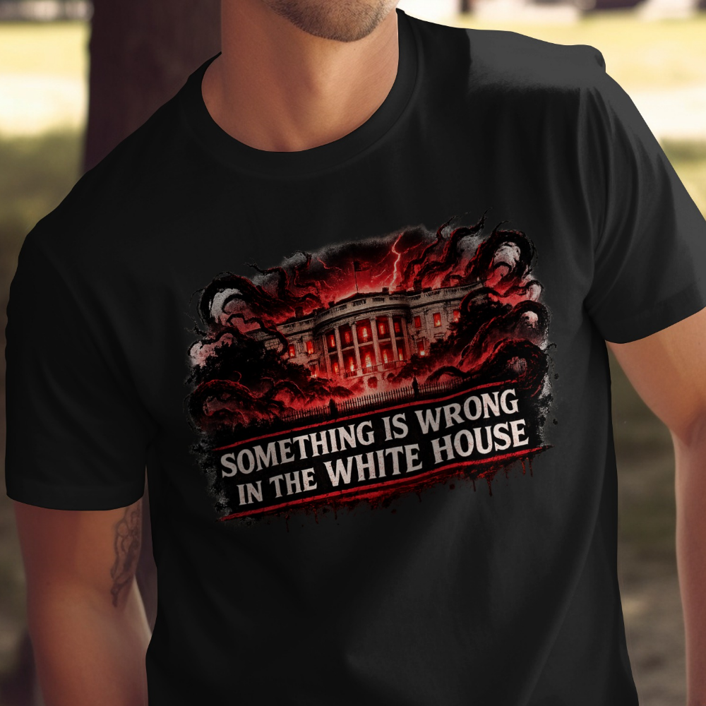 Black t-shirt featuring White House engulfed in dark tendrils and red lightning, text reads "SOMETHING IS WRONG IN THE WHITE HOUSE".