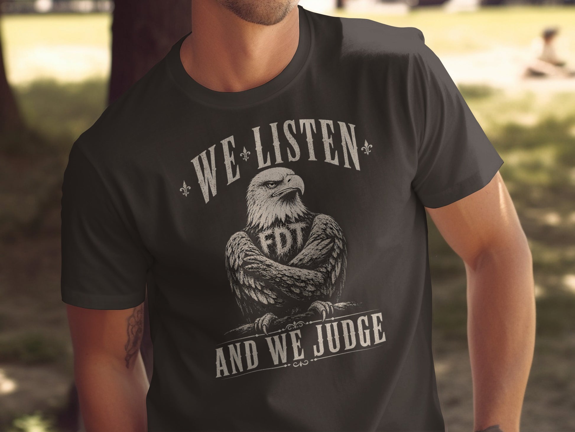 Dark t-shirt with eagle graphic and text "WE LISTEN AND WE JUDGE".