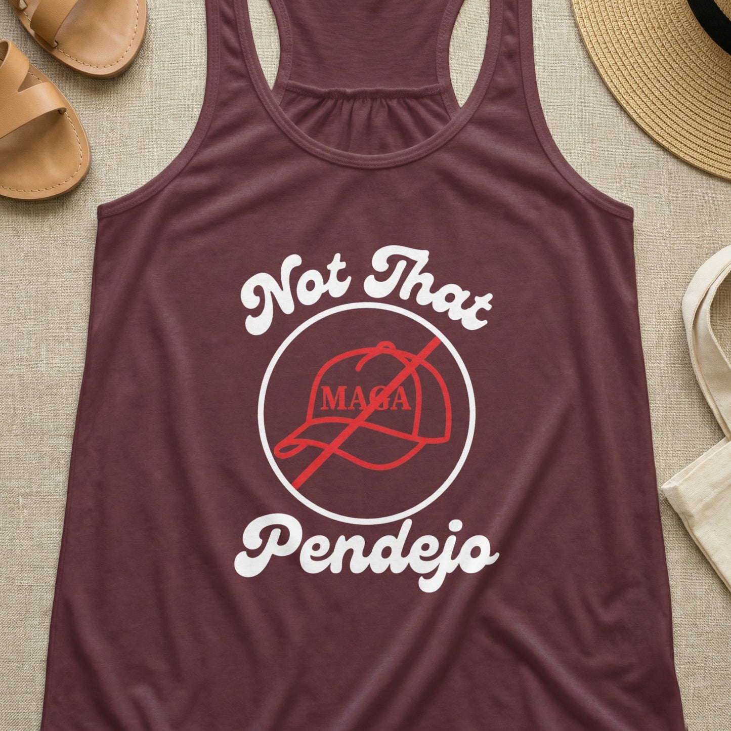 Maroon tank top with "Not That MAGA Pendejo" text and crossed-out hat graphic.
