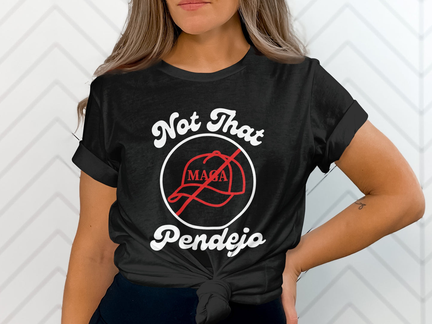 Black t-shirt with "Not That Pendejo" and a red MAGA hat crossed out.