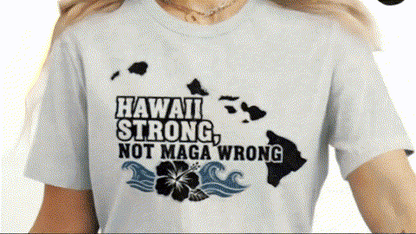 A person wearing a white t-shirt with a graphic design that says "Hawaii Strong, Not Maga Wrong" along with a map of Hawaii.