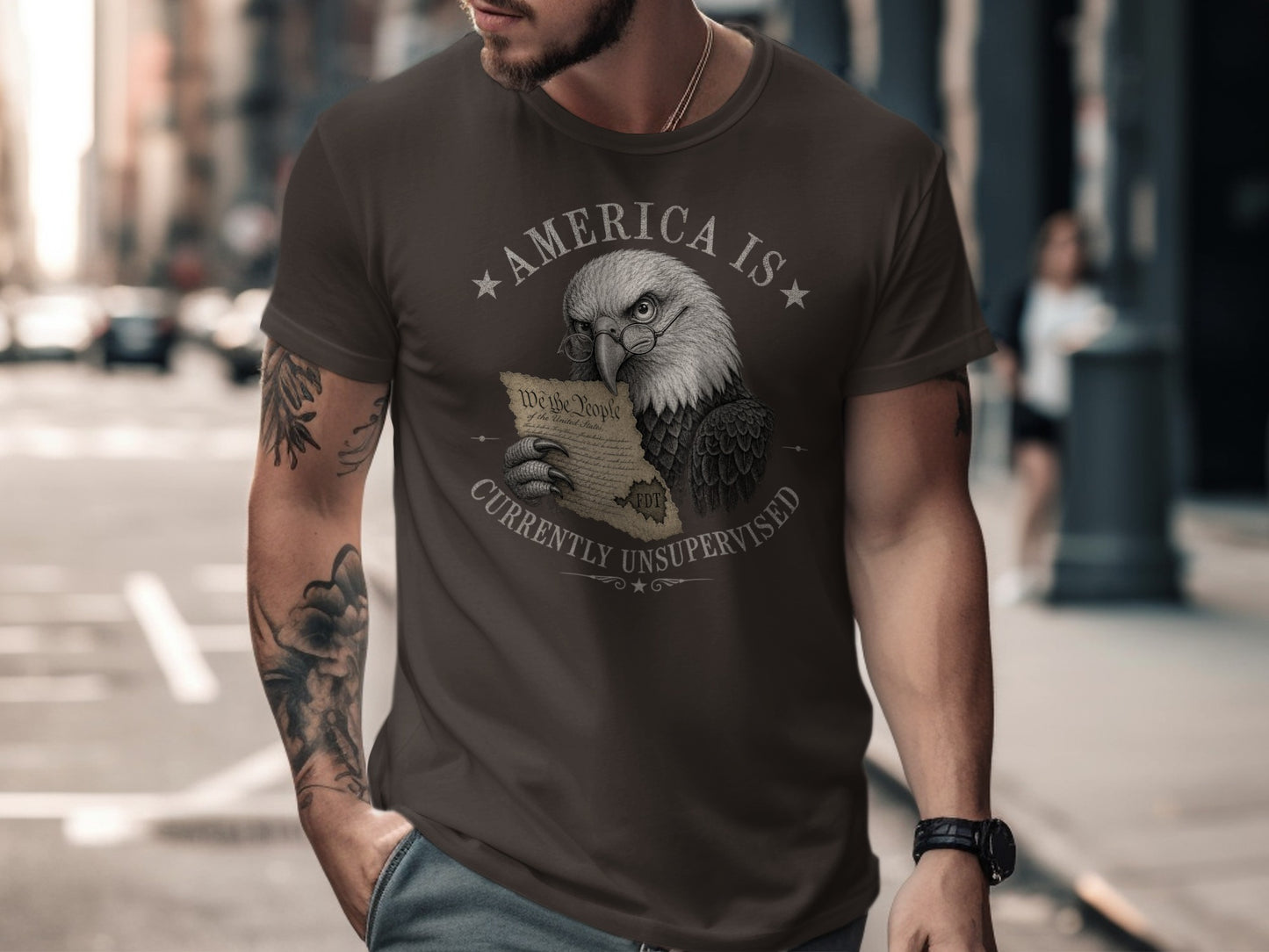 Eagle wearing glasses holds U.S. Constitution on dark t-shirt.