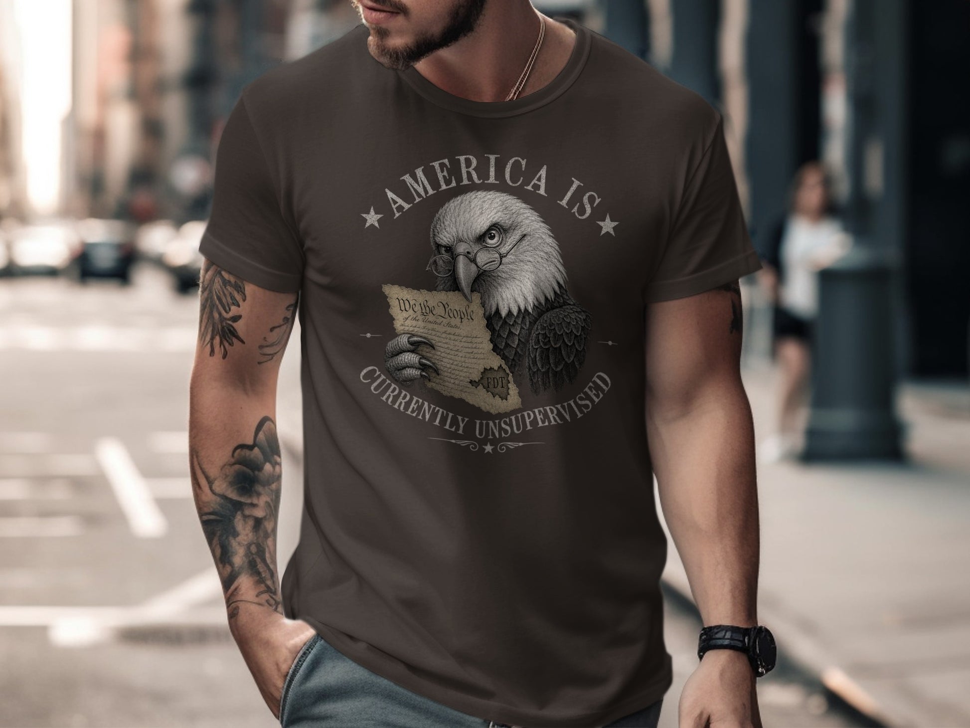 Eagle wearing glasses holds U.S. Constitution on dark t-shirt.
