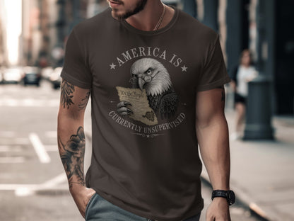 Eagle wearing glasses holds U.S. Constitution on dark t-shirt.