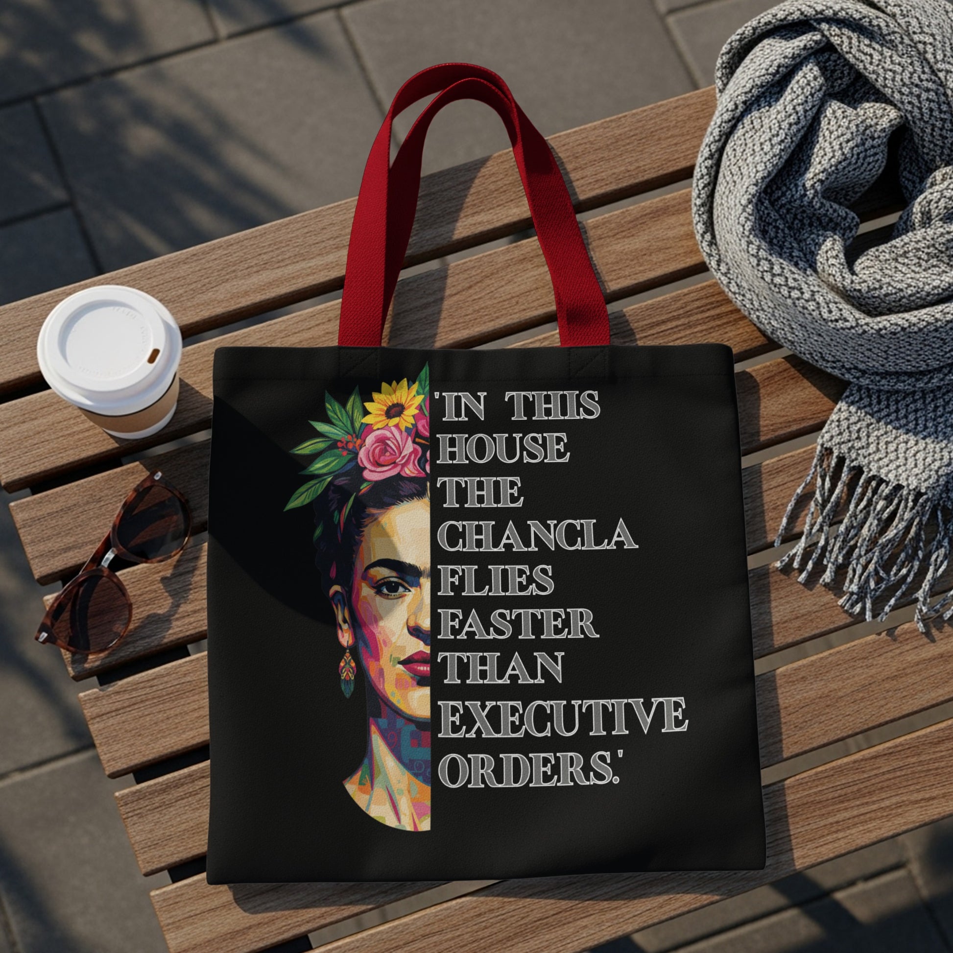 Black tote bag with Frida Kahlo portrait and quote "In this house the chancla flies faster than executive orders."