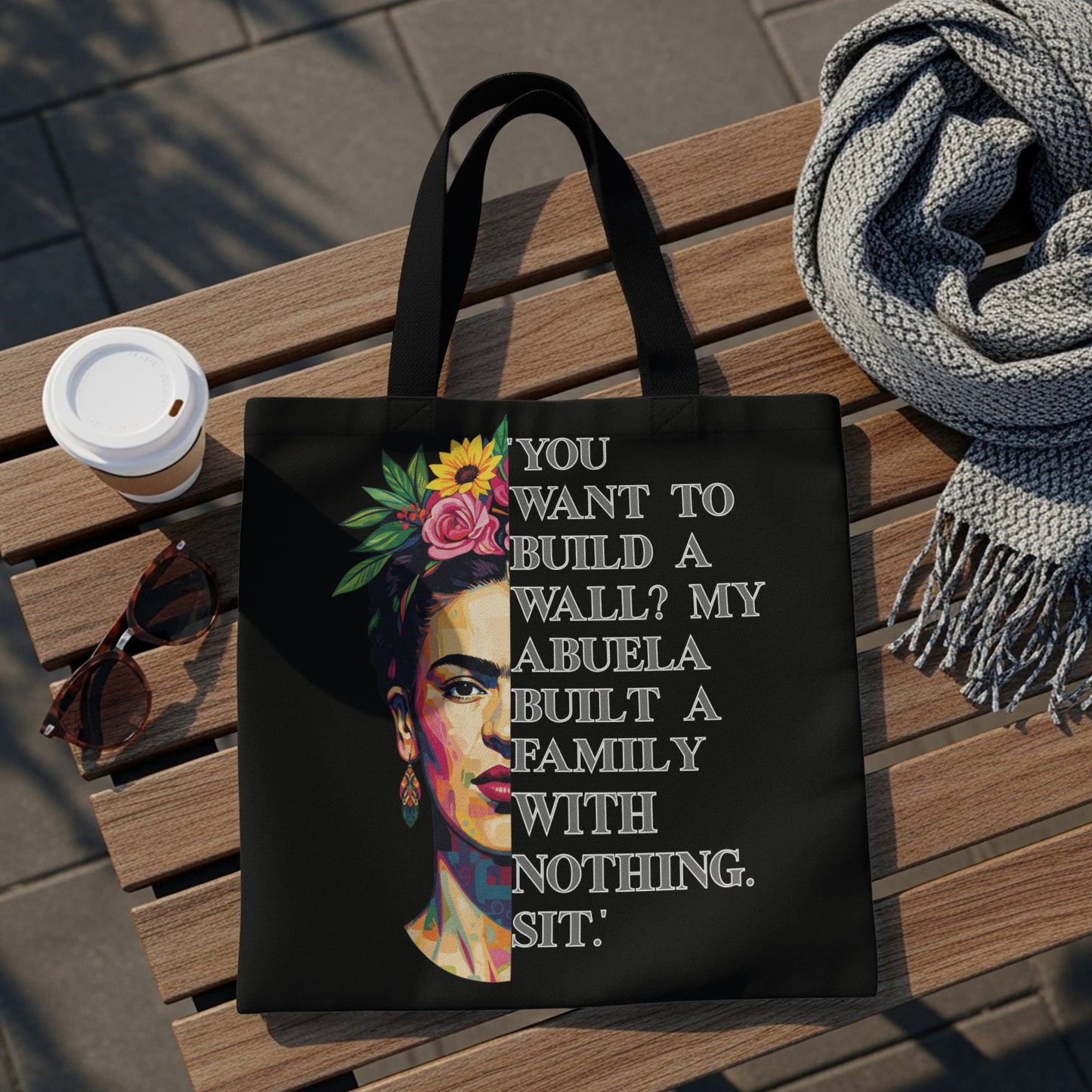 Black tote bag with Frida Kahlo portrait and quote "You want to build a wall? My abuela built a family with nothing. Sit."