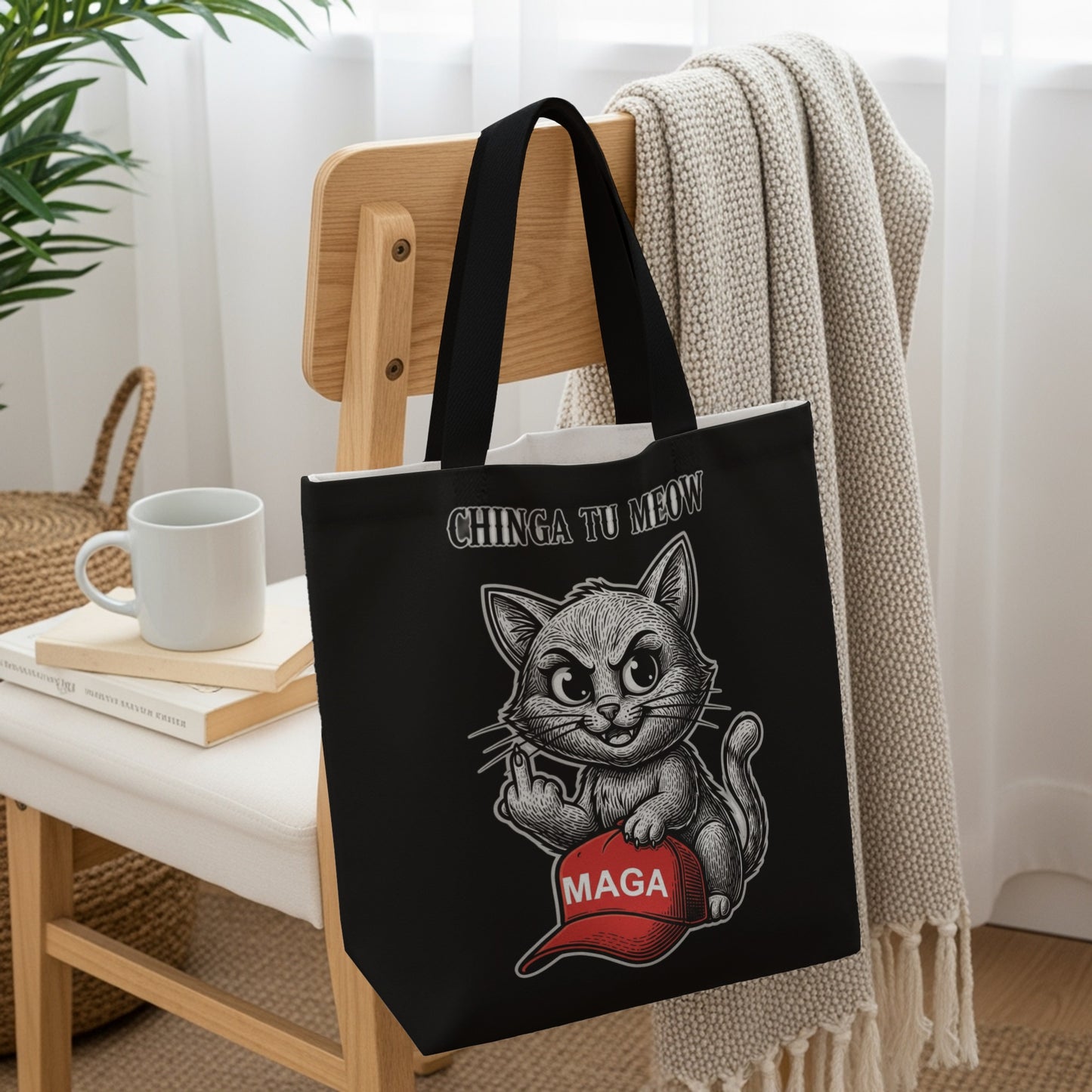 Black tote bag with a cartoon cat wearing a red MAGA hat and giving the middle finger.