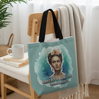 Tote bag featuring a watercolor portrait of Frida Kahlo with the text "AMERICA RUNS ON IMMIGRANTS".