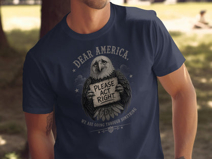 Navy t-shirt with distressed eagle holding sign reading "DEAR AMERICA, PLEASE ACT RIGHT. WE ARE GOING THROUGH SOMETHING".