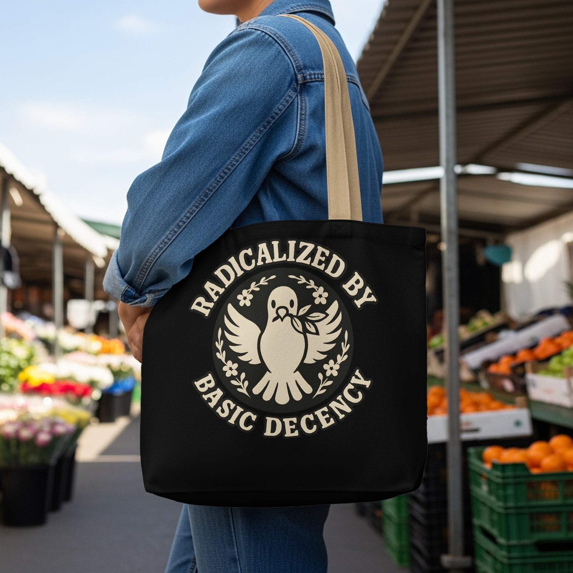 Black tote bag with dove and "Radicalized by Basic Decency" text.