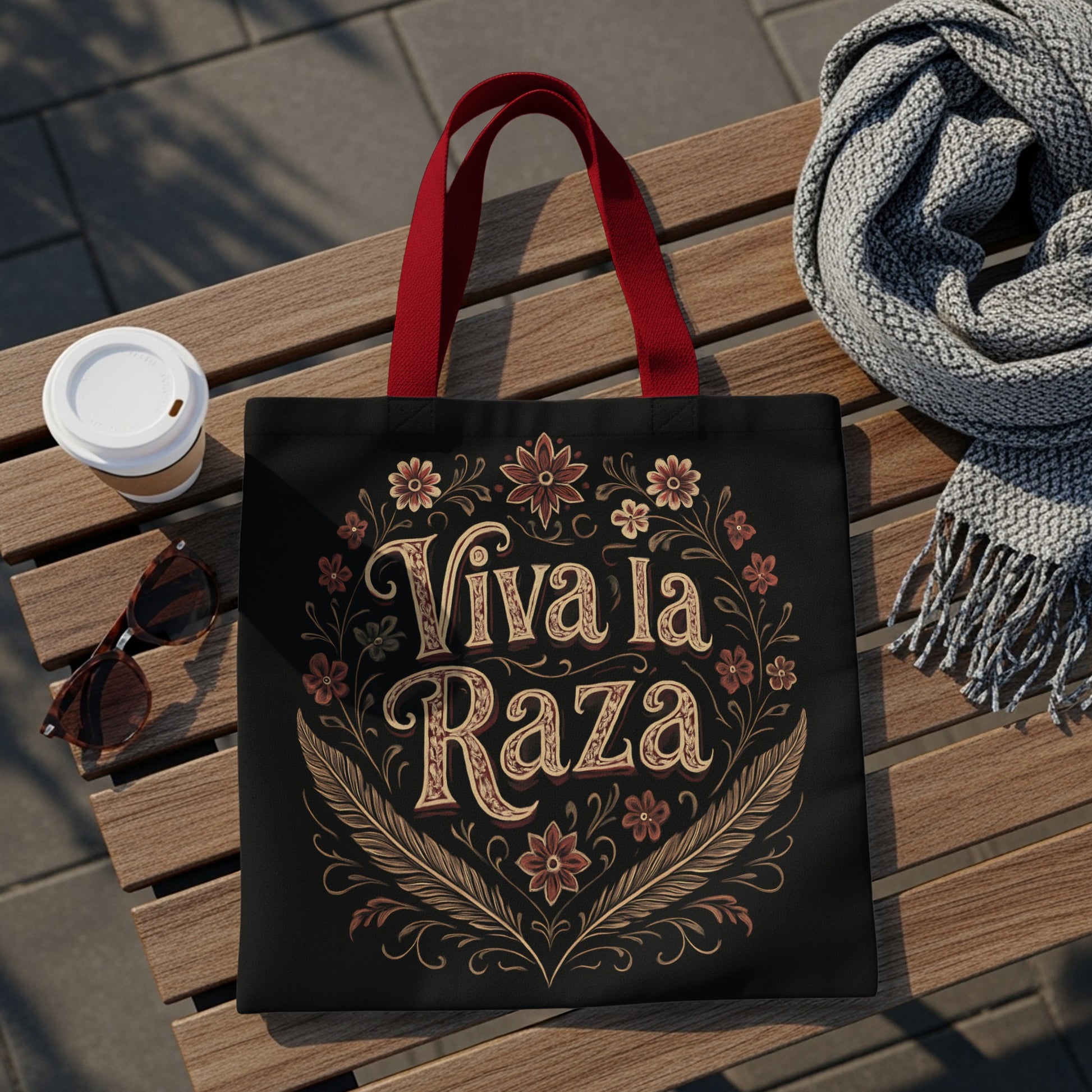 Black tote bag with "Viva la Raza" text and floral design.