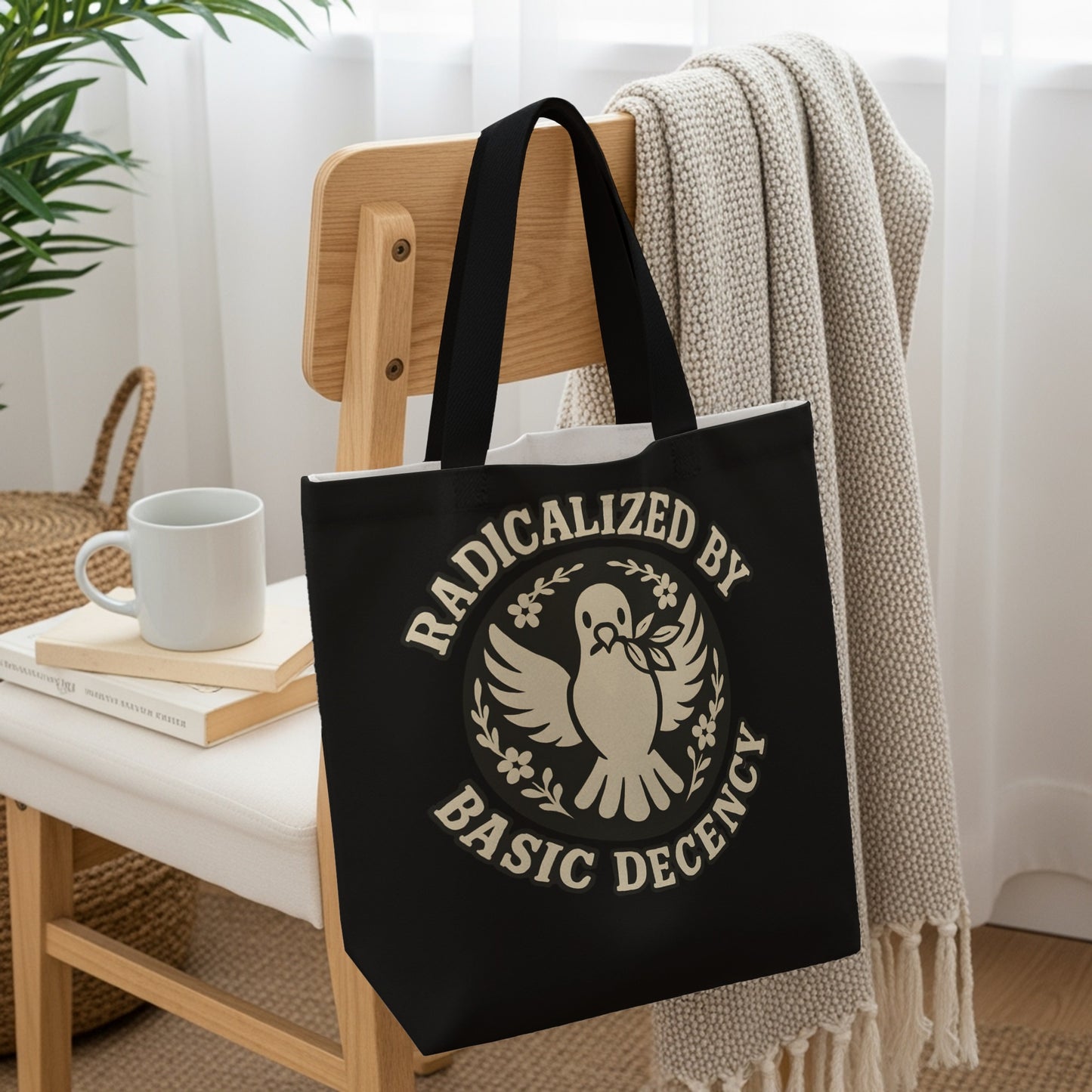 Black tote bag with dove of peace and "Radicalized by Basic Decency" text.