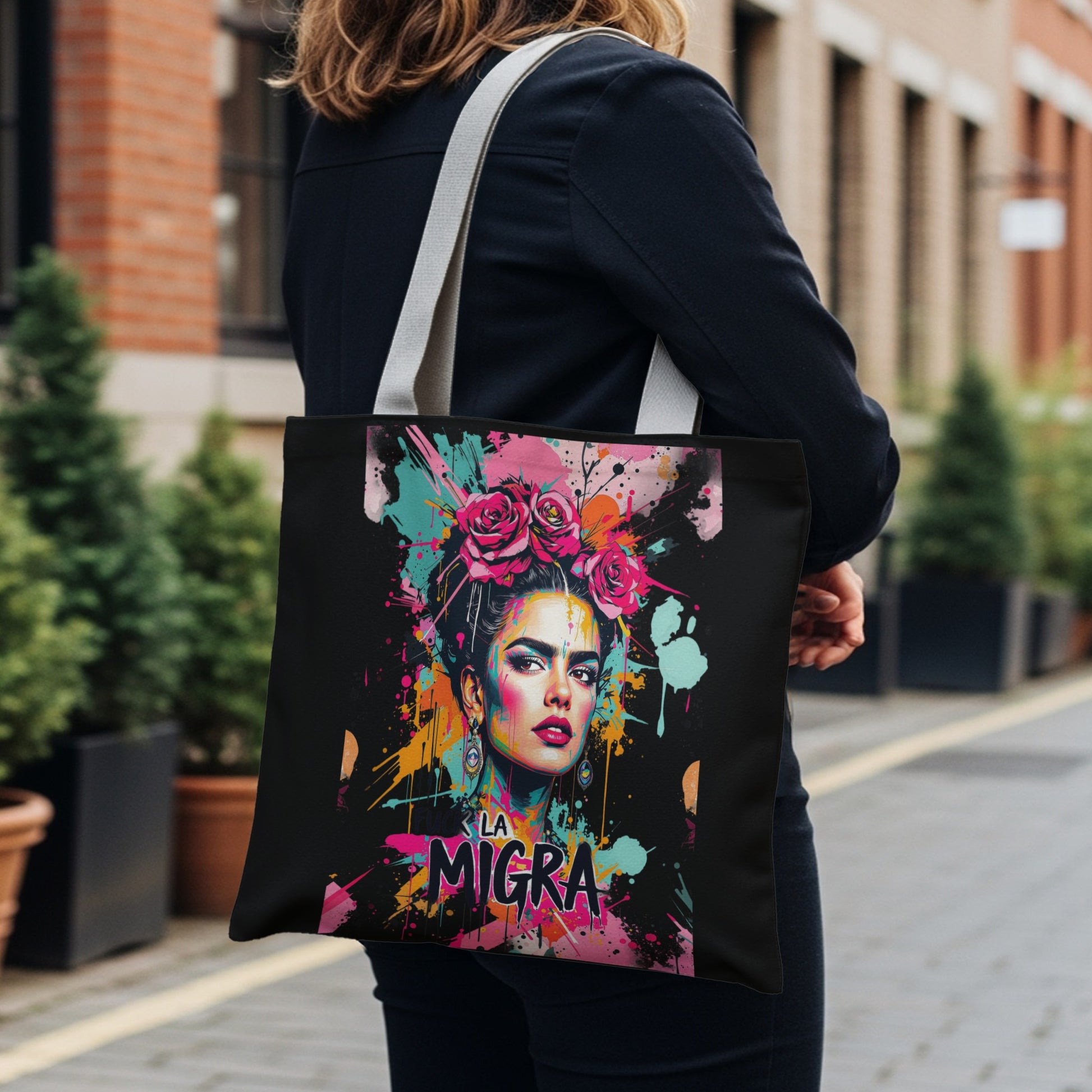 Tote bag with a vibrant Frida Kahlo-inspired portrait and "LA MIGRA" text.