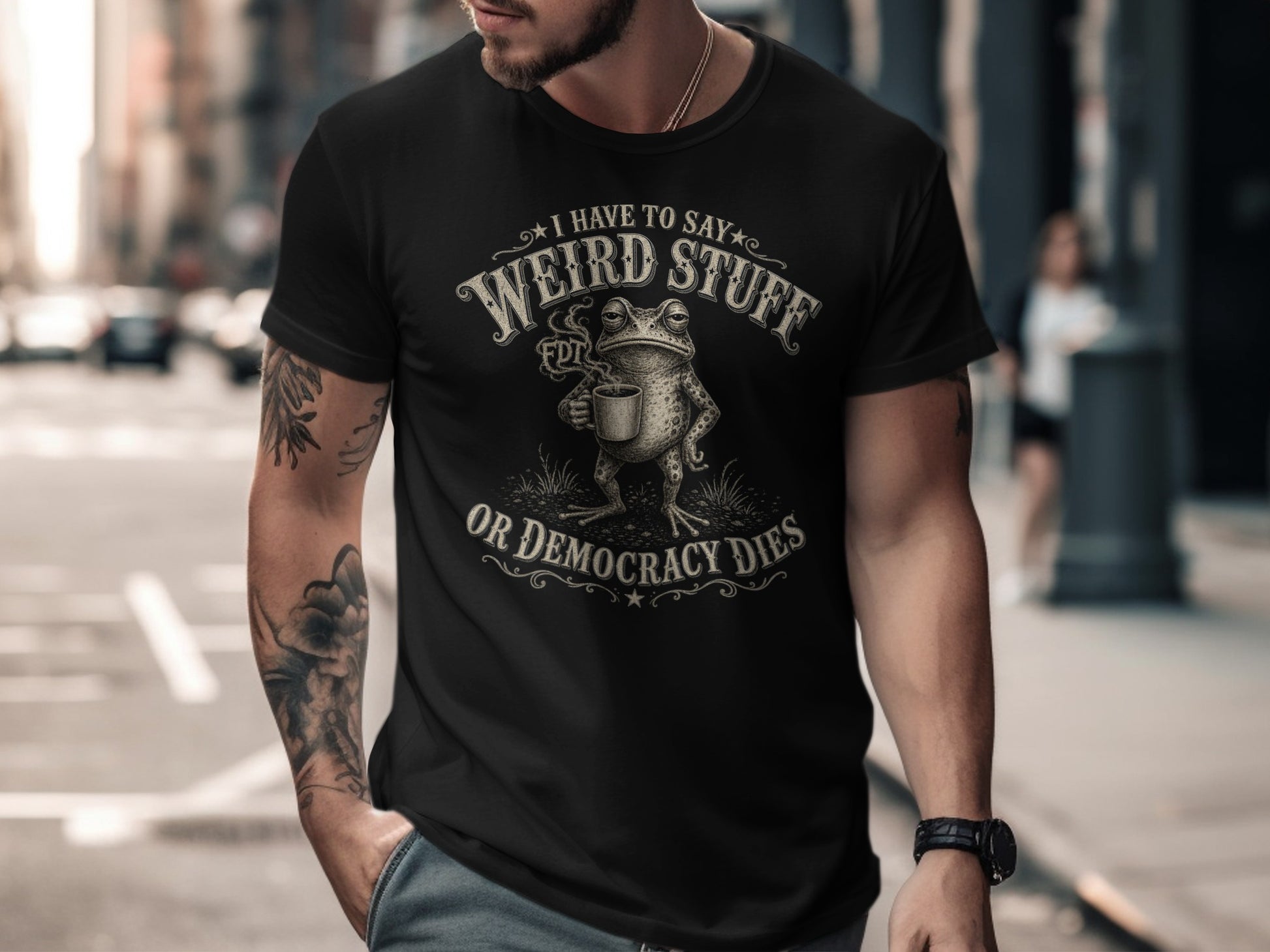 Black t-shirt with text "I have to say weird stuff or democracy dies" and a frog.